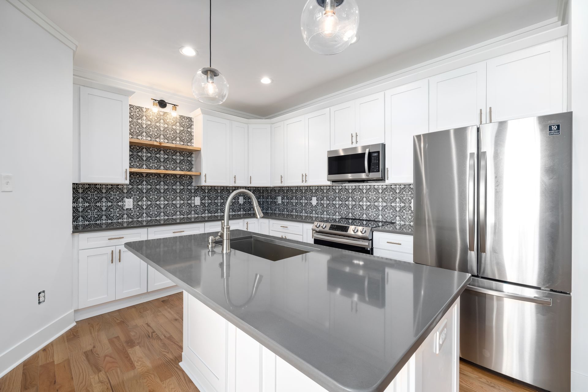 Sleek modern kitchen featuring a spacious island and stainless steel appliances, perfect for culinary enthusiasts.