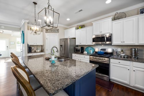 Free Spacious and elegant modern kitchen with a granite island and white cabinets. Stock Photo