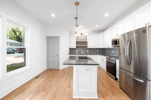 Free Sleek modern kitchen featuring stainless steel appliances, white cabinets, and an island counter. Stock Photo