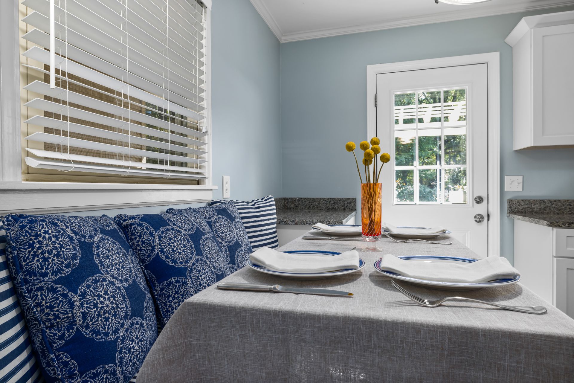 Charming dining space featuring a neat table setting with floral cushions, ideal for home interiors.