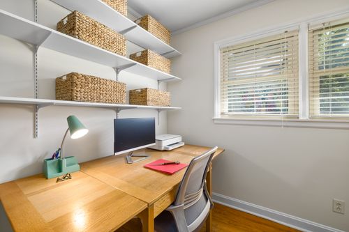 Free Stylish home office setup with wooden desk and wicker storage baskets. Stock Photo