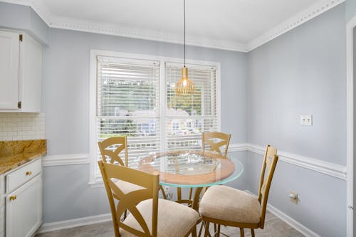 Glass Dining Table with Wooden Chairs at a Dining Room