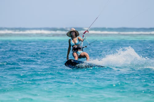 Woman in Blue Bikini Wakeboarding on Sea