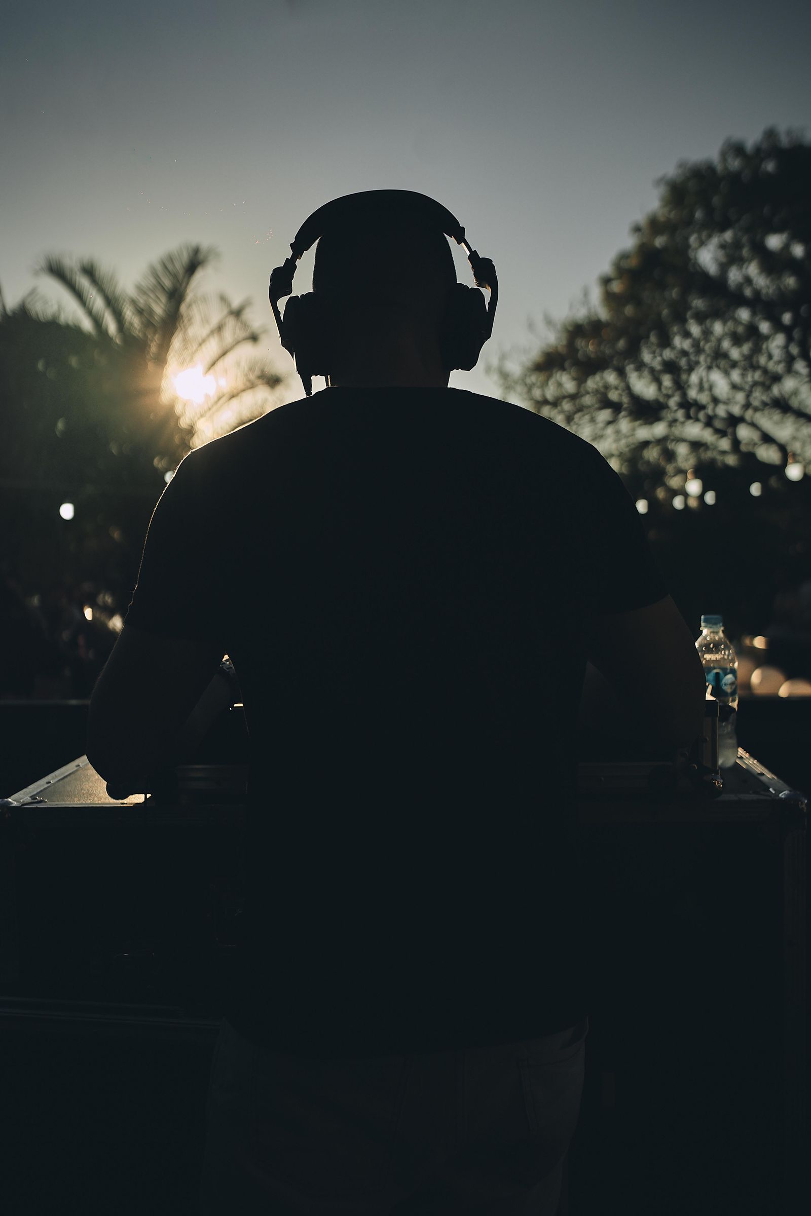 Silhouette of a DJ in headphones at dusk