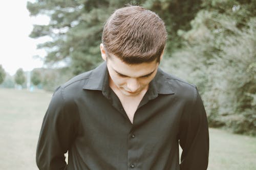 Man in Black Button Down Shirt Looking Down