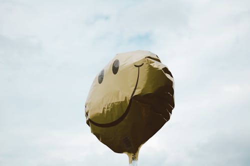 Smiley Face Balloon Under White Clouds