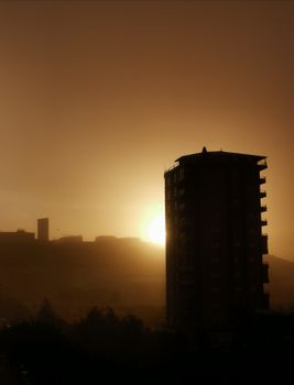 A silhouette of a high-rise building with a dramatic sunset backdrop.