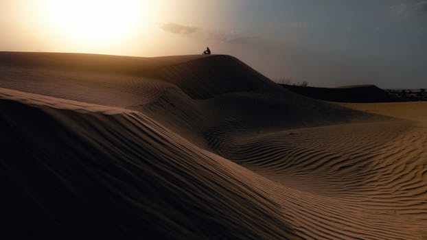 Explore the breathtaking sunset over the Sam Sand Dunes in Kanoi, Rajasthan, showcasing the beauty of India's arid landscapes.