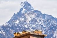 Brown Concrete Building Near Snow Covered Mountain