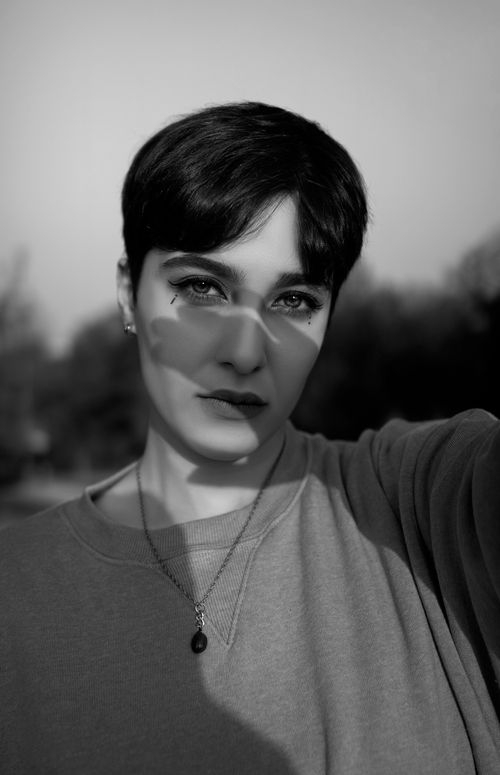 Free Artistic black and white portrait of a woman in a Tehran park, showcasing dramatic lighting and shadows. Stock Photo