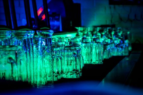 Free A vibrant display of illuminated drinking glasses in a Swiss bar, showcasing nightlife ambiance. Stock Photo