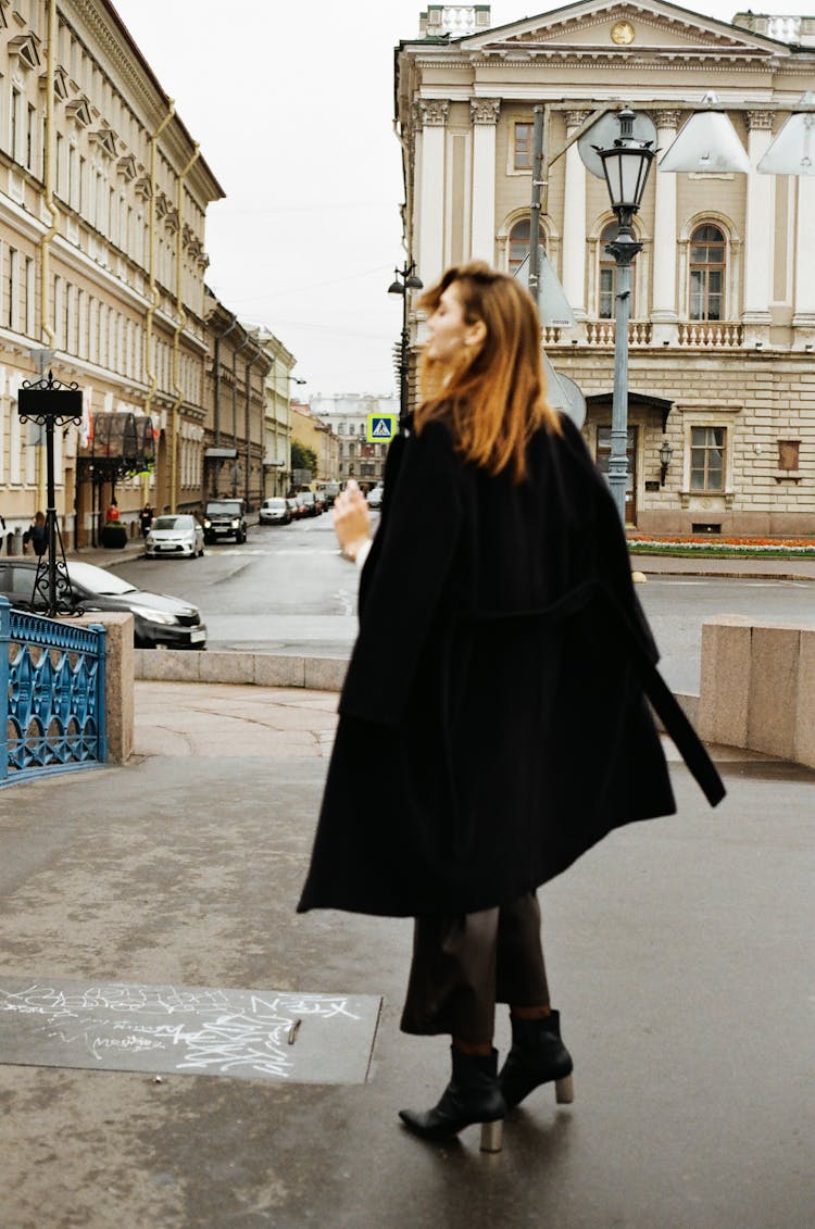 Woman In Long Coat Standing On Old Towns Plaza