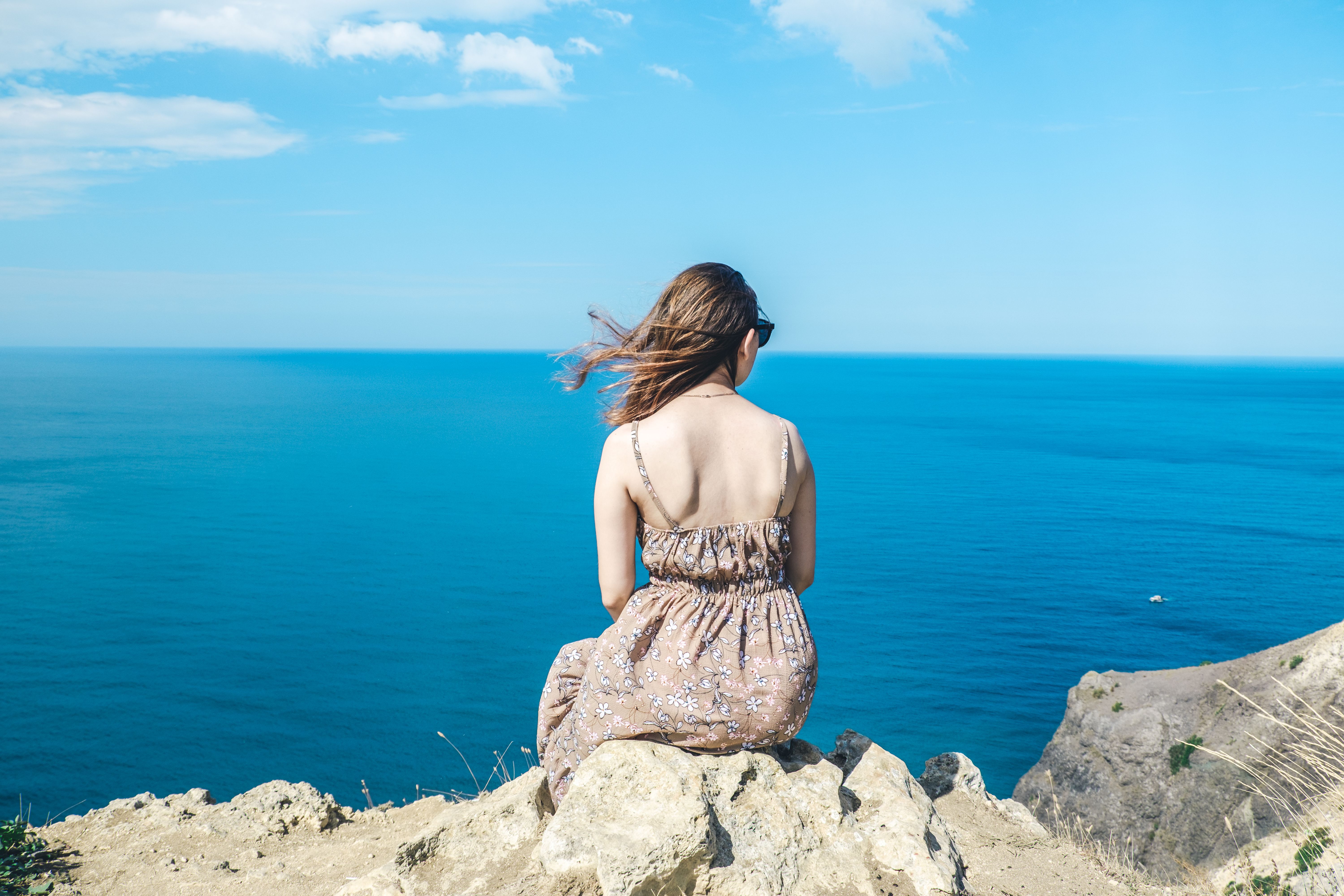 A Back View of a Woman Sitting on the Rock · Free Stock Photo