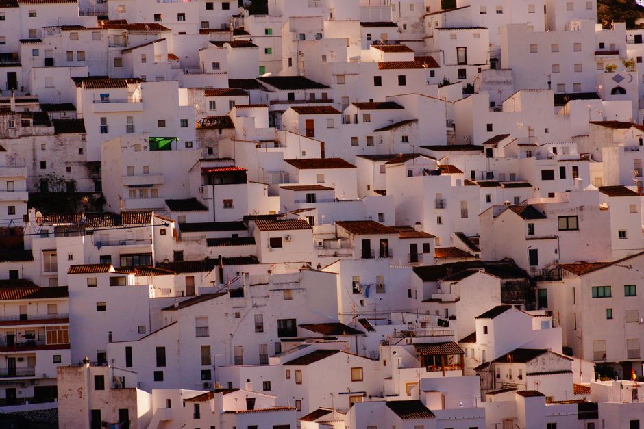 Una vista aérea escénica de casas blanqueadas densamente empacadas iluminadas por la cálida luz del sol.