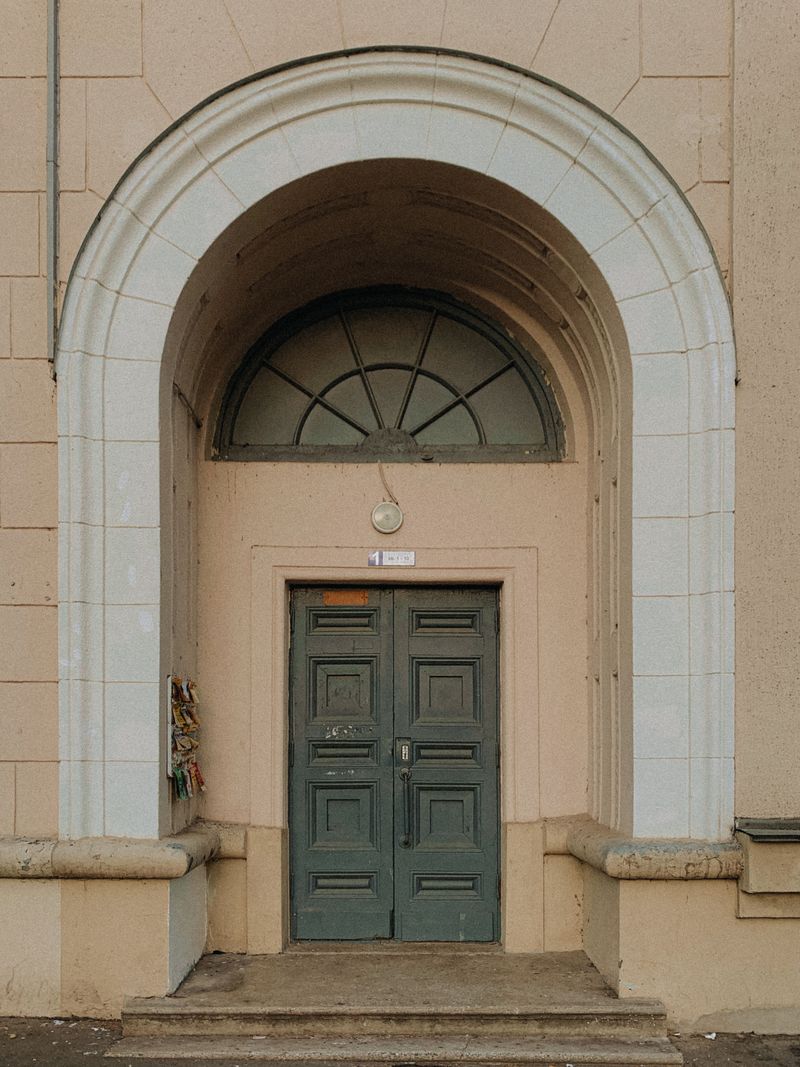 Arched entrance with a wooden door, photo by Darya on Pexels