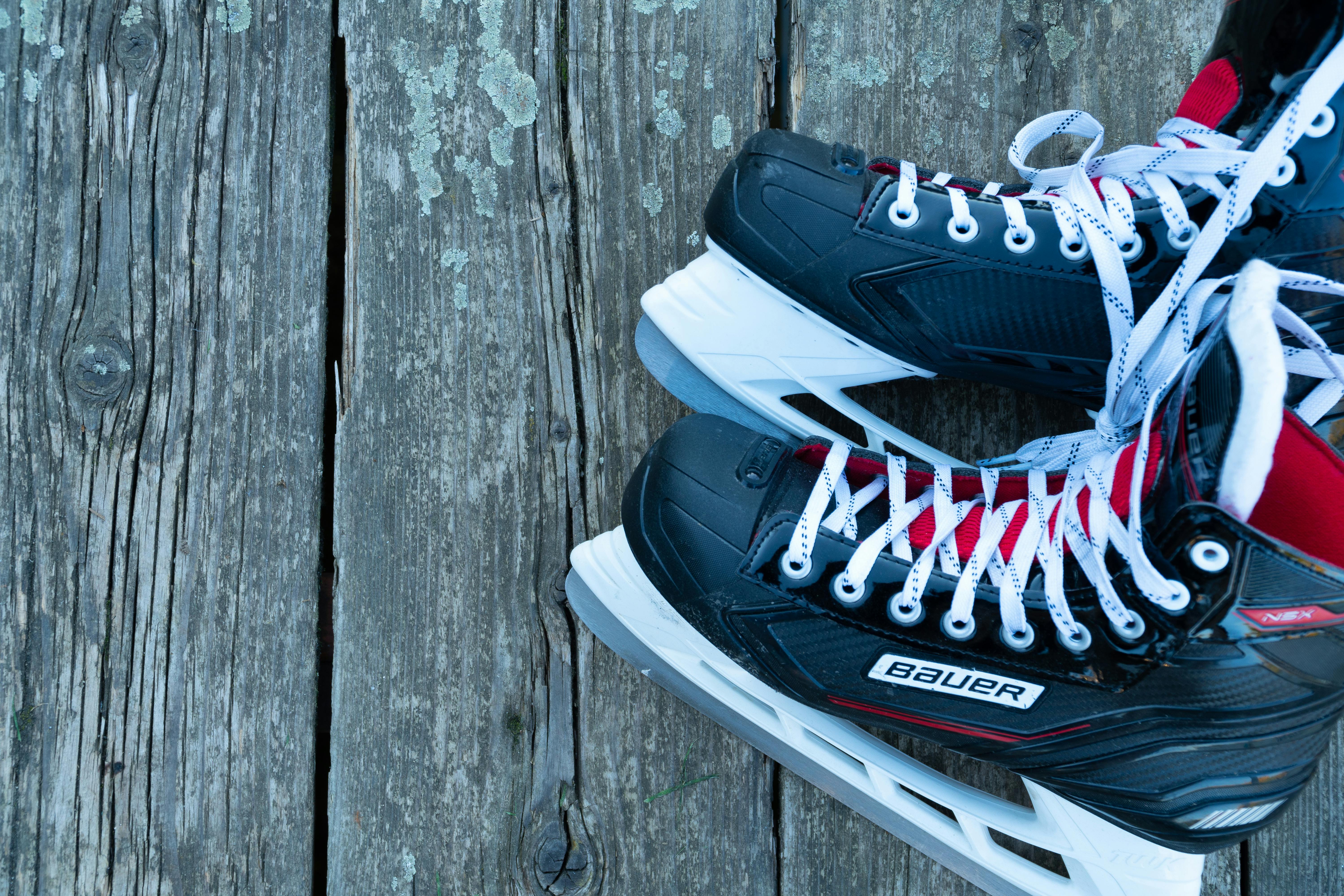 Hockey skates resting on a weathered wooden surface, perfect for sports-themed designs.