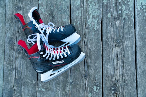 Free Ice Skating Shoes on a Wooden Floor Stock Photo