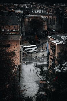 Aerial view showcasing an Edinburgh street with a prominent bus amidst historic architecture.