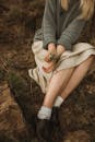 A Woman Wearing Socks and Black Leather Shoes Sitting on Brown Grass