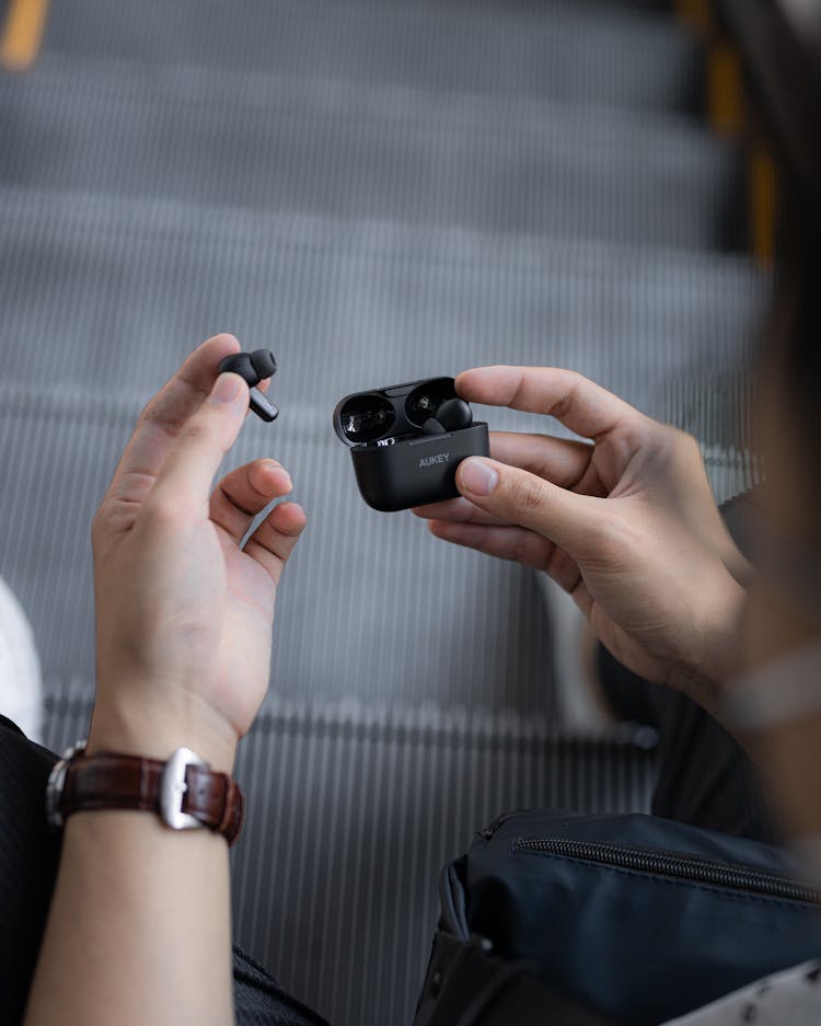 A Person Holding Black Earpods