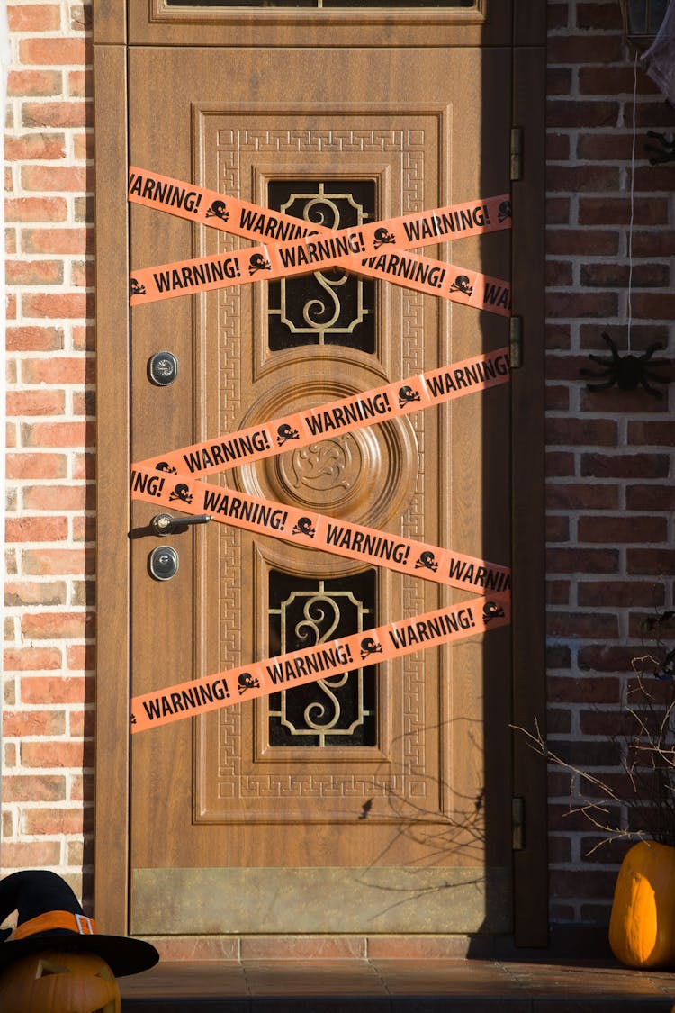 Photograph Of A Brown Door With Warning Tapes