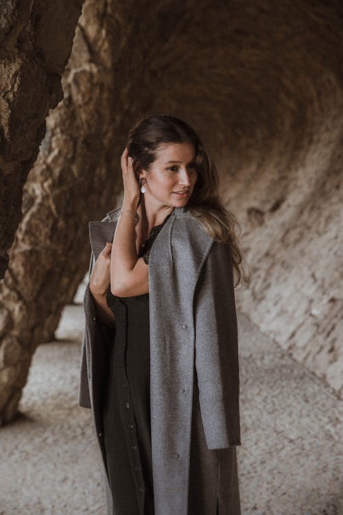 Photo of a Woman with a Gray Coat Touching Her Hair