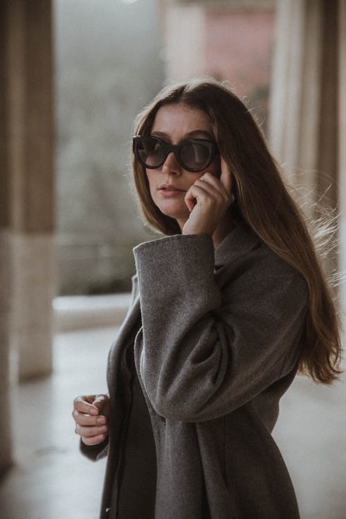 Portrait of a Woman in a Gray Coat Wearing Sunglasses