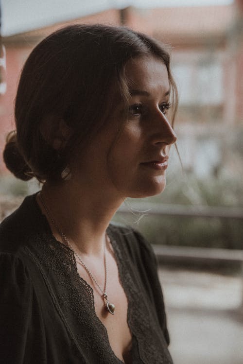 A Beautiful Woman in Black Shirt while Wearing Necklace