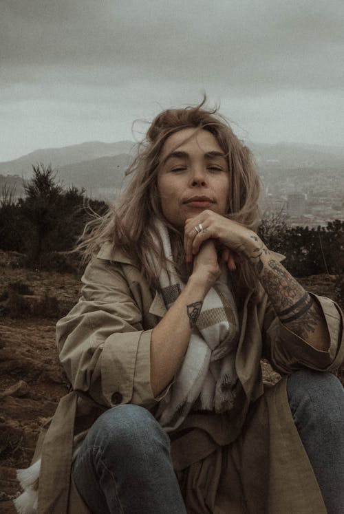 Blonde Sitting Outdoors on Windy Day