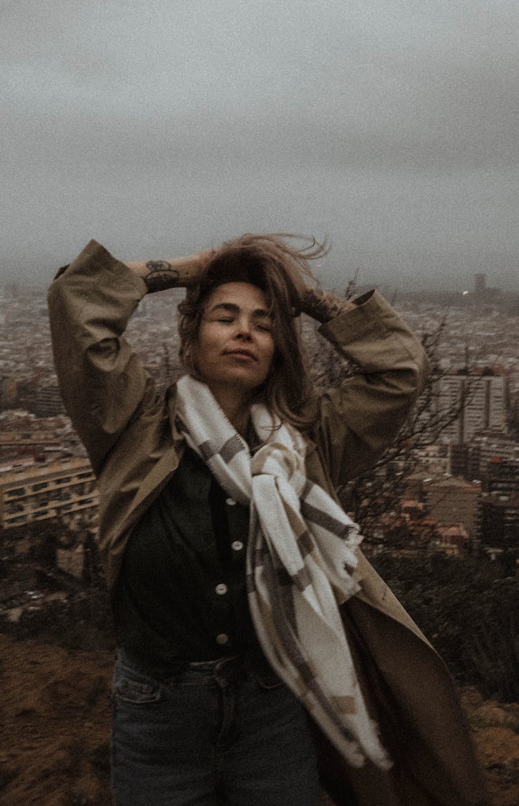 Photograph Of A Woman With A White Scarf Posing With Her Hands On Her Head