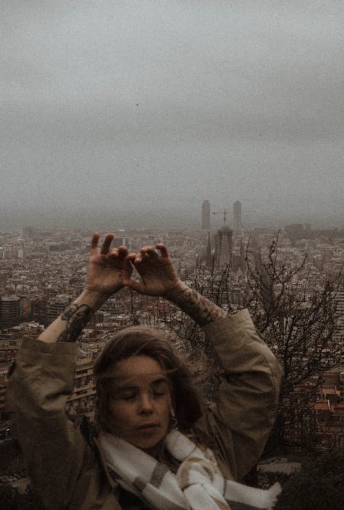 Woman Standing With Raised Arms Against a Cityscape