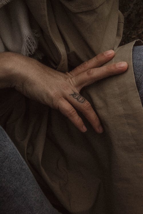 Close-Up Photograph of a Person's Hand with a Finger Tattoo