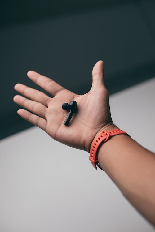 Free Photo of a Black Earphone on a Person's Palm Stock Photo