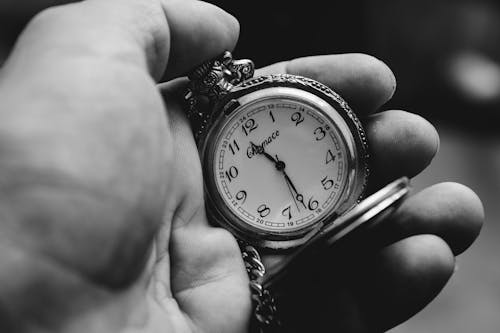 Free A Person Holding a Pocket Watch Stock Photo