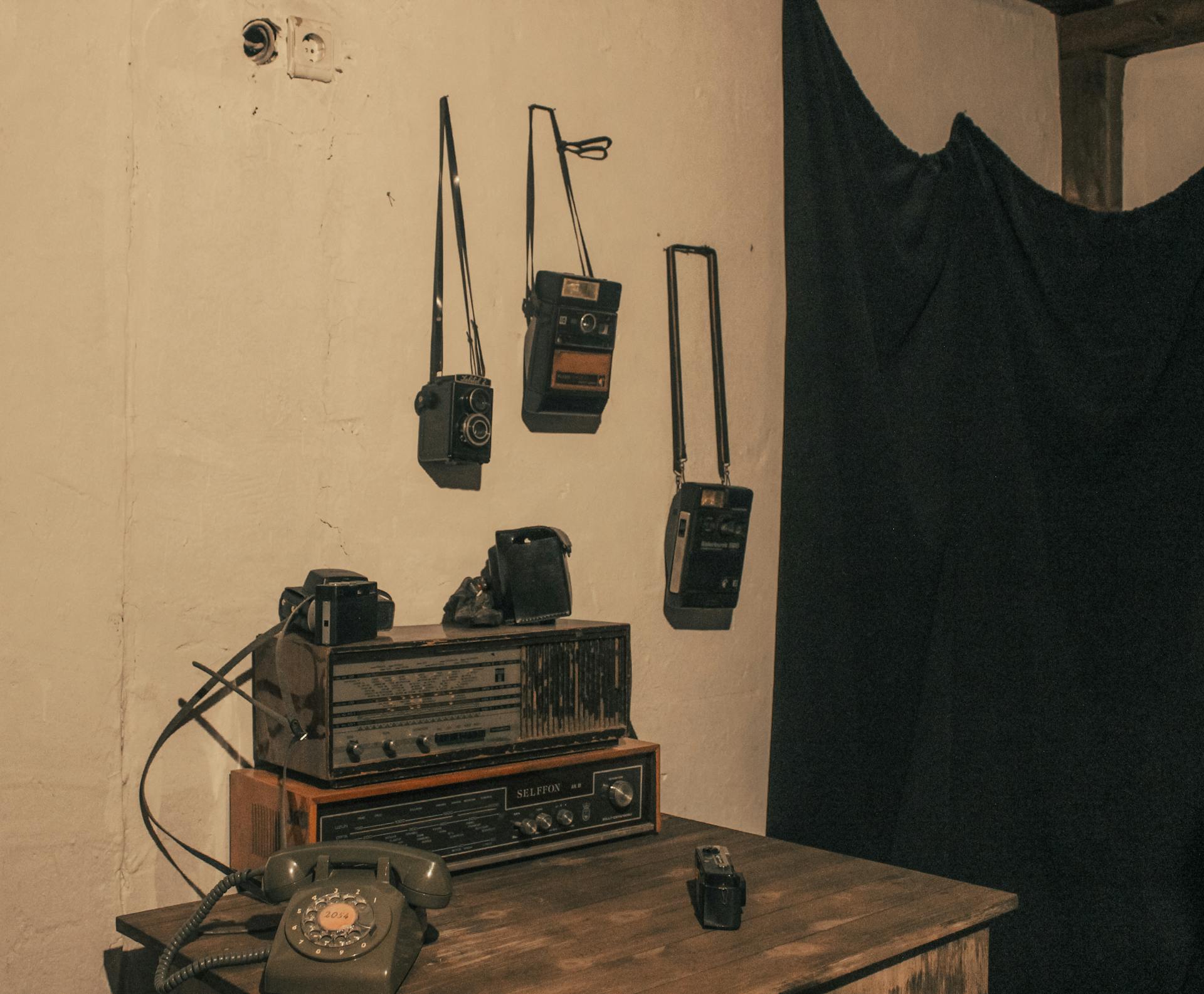 A collection of vintage cameras and radio in a retro room setting, capturing nostalgia and old-world charm.