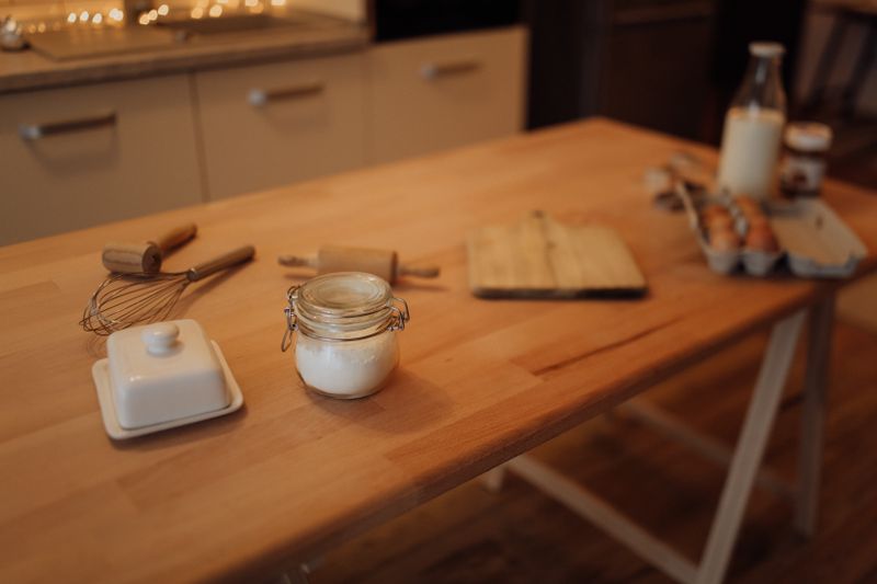 A warm, inviting kitchen scene showcasing essential baking ingredients and tools on a wooden table.