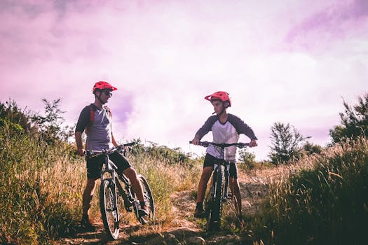 Two Man Riding Mountain Bike on Dirt Road at Daytime