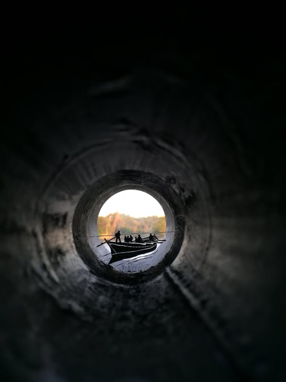 People Riding Canoe Boat View from Inside Pipe