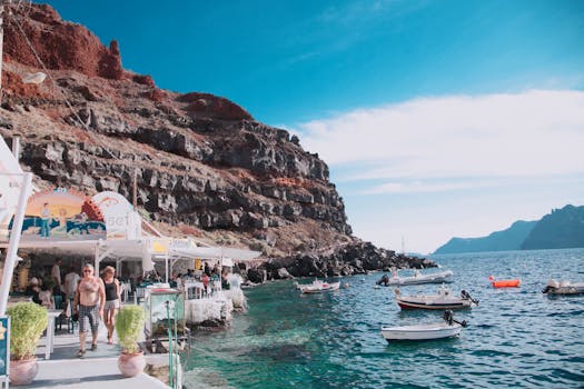 希腊圣托里尼岛拥有风景如画的沿海风光，以船只和充满活力的海滨咖啡馆为特色