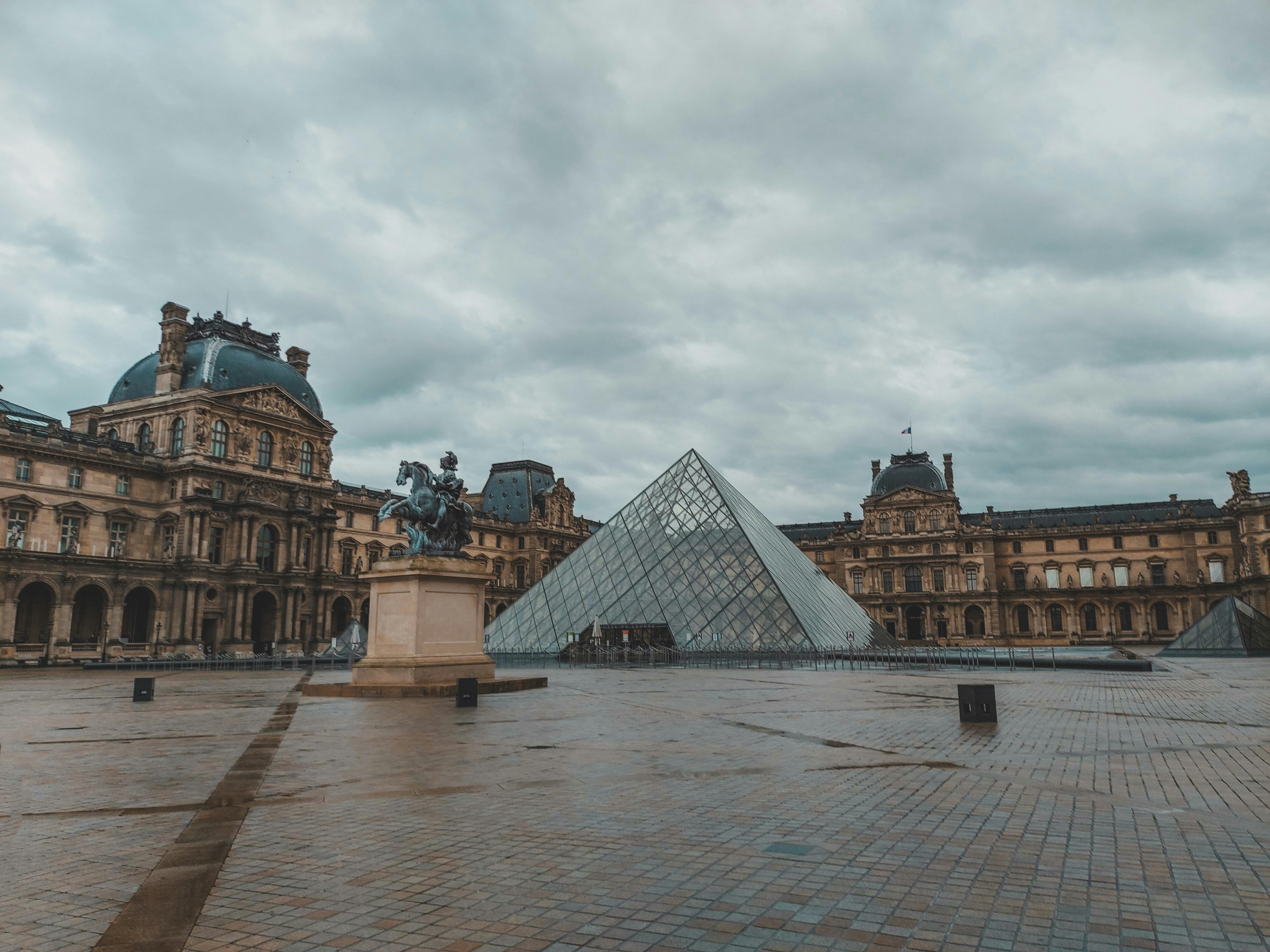 a louvre museum under the cloudy sky