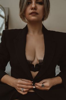 Elegant portrait of confident woman in black blazer with fashion ring and manicure.