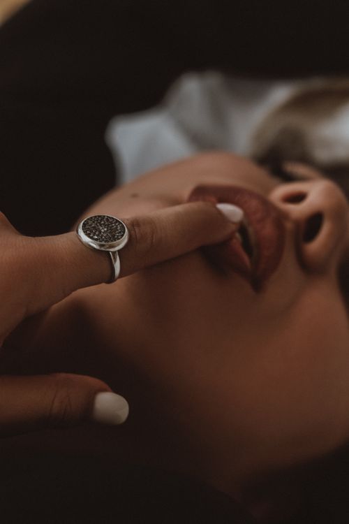 Free Intimate close-up of a woman with lips and finger adorned by a ring, creating a sensual mood. Stock Photo