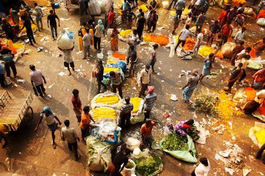 Vibrant bustling market scene with vendors and colorful produce in India, captured from above.