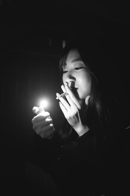 Black and White Shot of a Woman Lighting Up her Cigarette