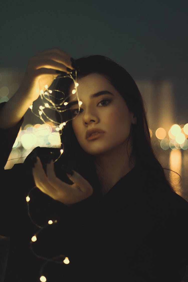 A Woman Holding String Lights