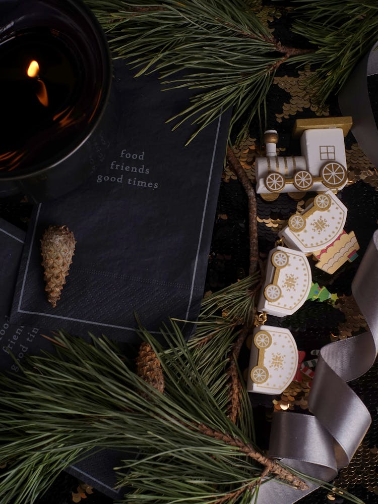 Christmas Flat Lay Of Candle, Handkerchief, Toy Train And Twigs