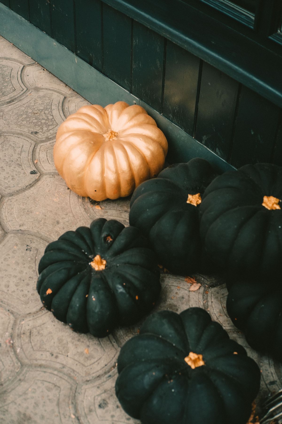 Black and gold pumpkins on a doorstep for a cool modern Halloween porch