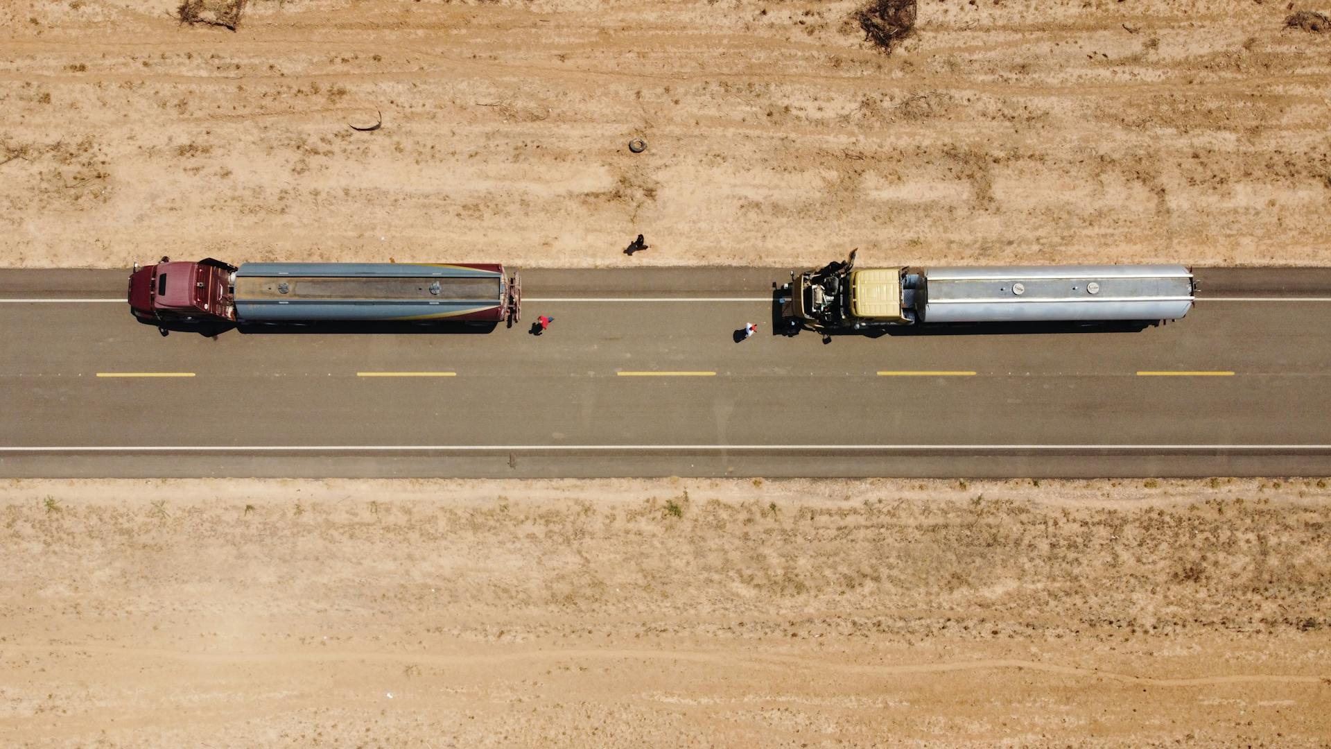 Drone shot of two trucks on a rural road in Independencia, Paraguay.