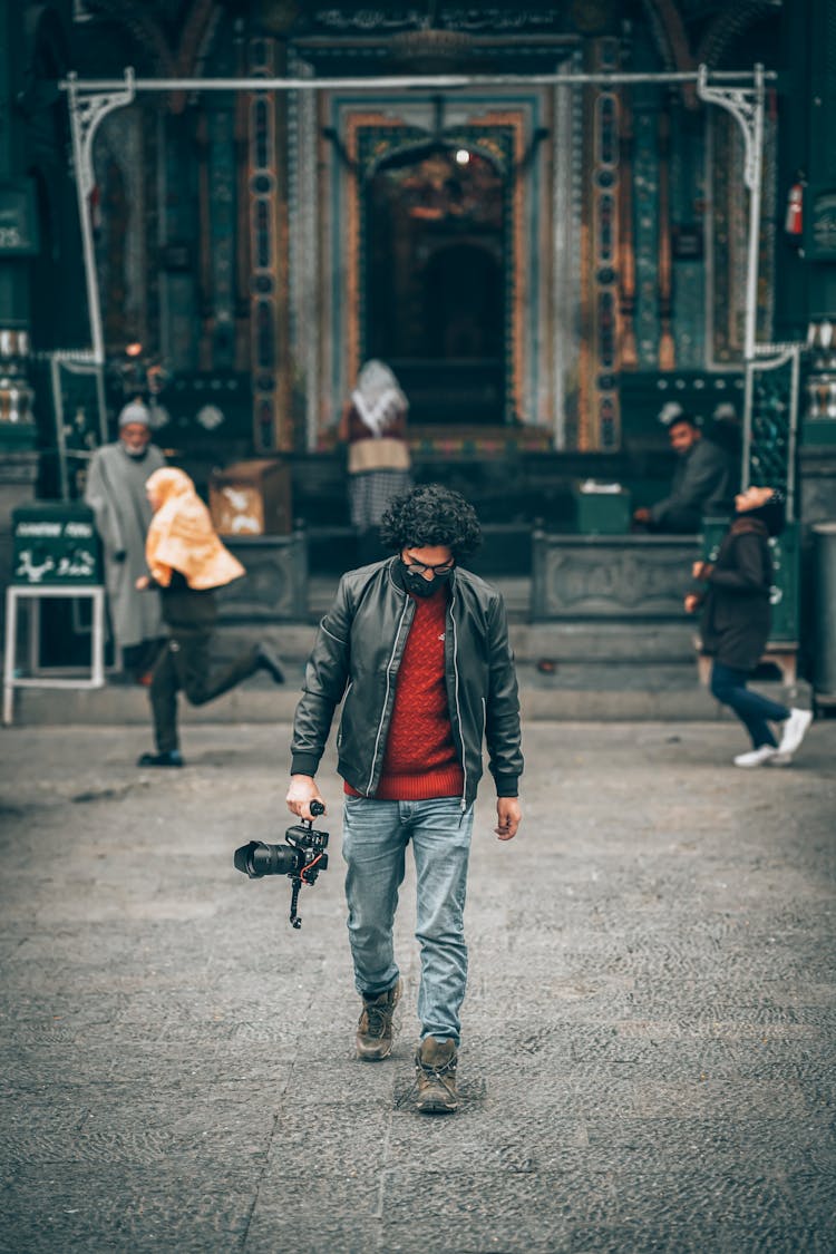 A Man Holding A Professional Camera