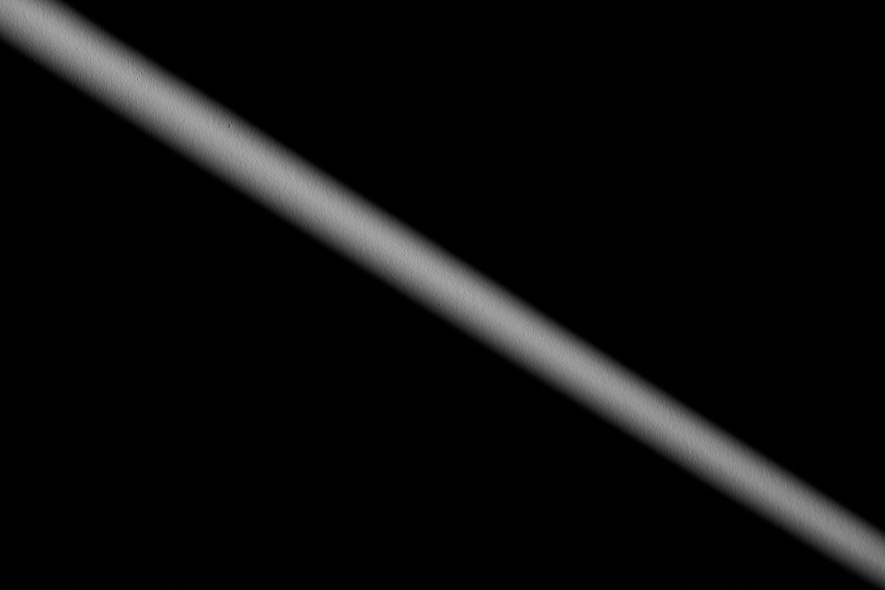 minimalist image featuring a diagonal shadow across a dark background